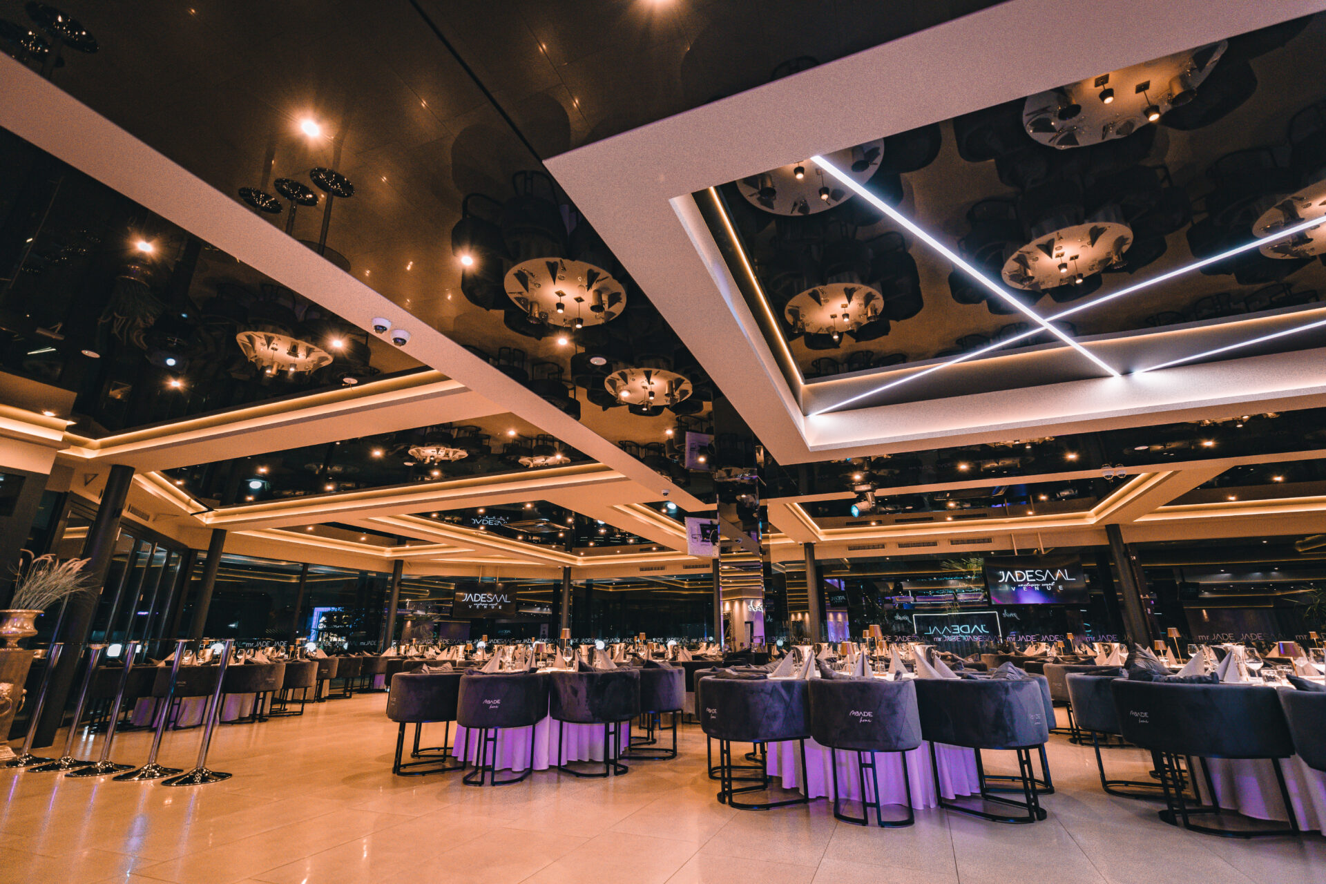 Weitwinkelaufnahme eines modernen Festsaals mit dunklem Decken-Design und Lichtelementen